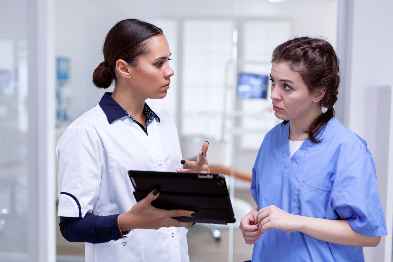 Dentist looking at nurse explaining teeth infection